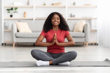 Rahat Afro-Amerikan kadın evde meditasyon yapıyor.