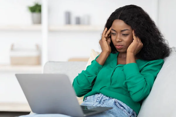 Κουρασμένη μαύρη γυναίκα ελεύθερη επαγγελματίας που εργάζεται σε φορητό υπολογιστή, που πάσχουν από πονοκέφαλο — Φωτογραφία Αρχείου
