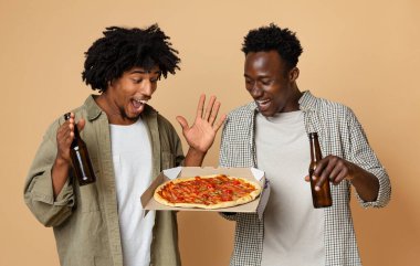 İki Heyecanlı Siyah Arkadaş 'ın Portresi Bira Şişeleri ve Pizza Tutuyor