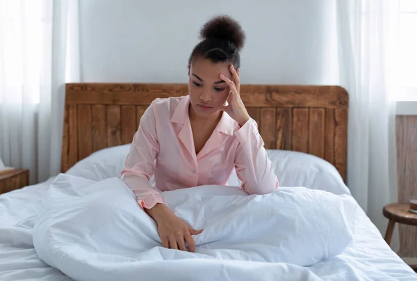 Bunalımlı Afrikalı Amerikalı kadın uyuyamıyor, baş ağrısı, stres ve uykusuzluk çekiyor, yatakta oturuyor, boşluğu kopyalıyor. — Stok fotoğraf