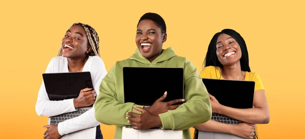 Tech Lovers Concept. Joyful Black Women Embracing Laptops With Blank Screens — Stockfoto