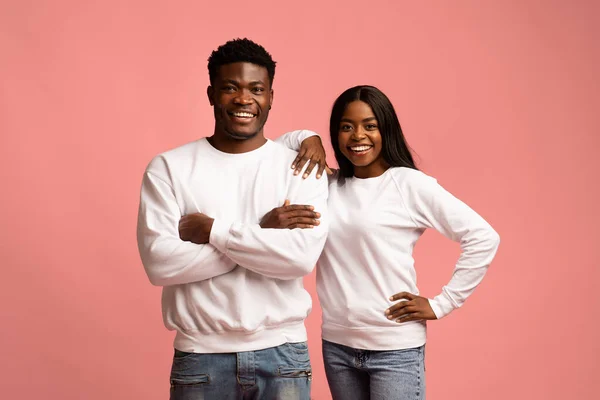 Positive attractive black couple cuddling on pink — Foto Stock