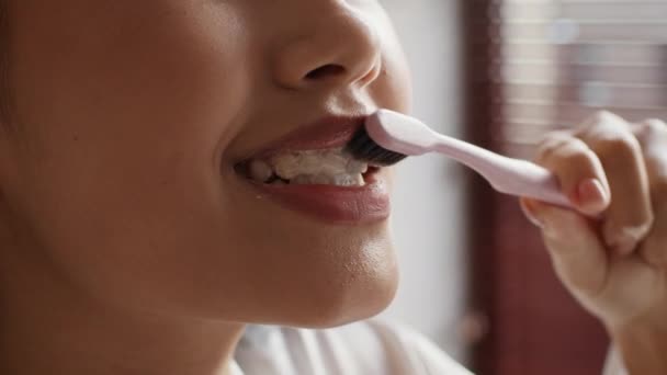 Mujer asiática irreconocible limpiando dientes con cepillo de dientes en el baño, primer plano — Vídeo de stock