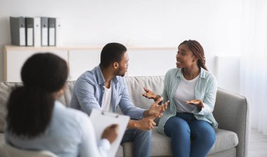 Genç siyahi çift evlilik terapisi sırasında psikologla ofisteki panorama