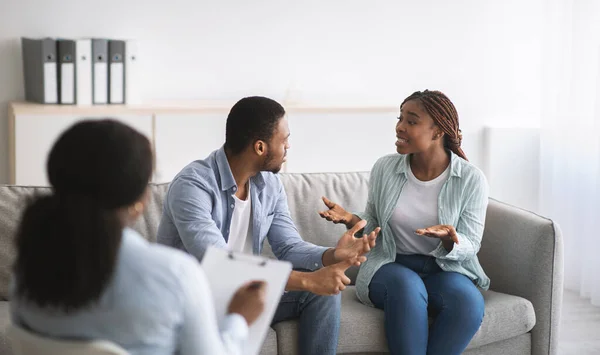 Jong zwart echtpaar in conflict tijdens echtelijke therapie met psycholoog op kantoor, panorama — Stockfoto