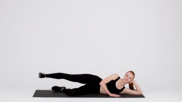 Young Sporty Woman Doing Side Leg Lift Exercise In Studio — Video Stock