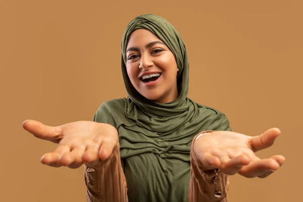 Ευτυχισμένος ενθουσιασμός. Ενθουσιασμένη γυναίκα με χιτζάμπ που κοιτάζει και απλώνει τα χέρια της στην κάμερα, αντιδρώντας συναισθηματικά στα καλά νέα. — Φωτογραφία Αρχείου