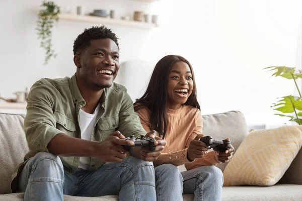 Joyful black couple playing video games at home — 스톡 사진