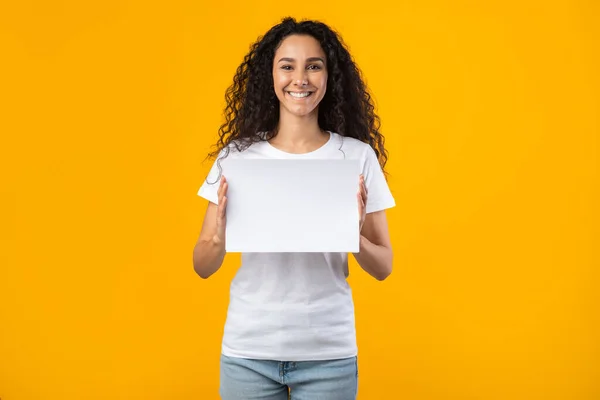 Happy Lady Holding Empty Paper Board Standing Over Yellow Background — Stockfoto