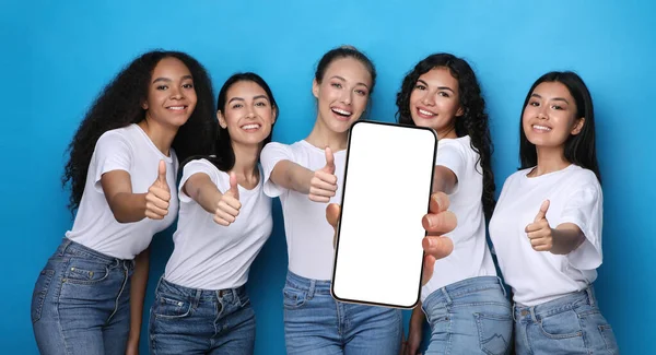 Mujeres felices mostrando la pantalla vacía del teléfono inteligente y pulgares hacia arriba — Foto de Stock