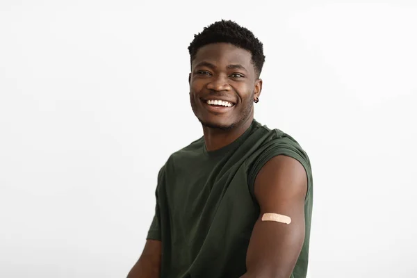 Positive handsome black man showing adhesive band on shoudler — Foto Stock