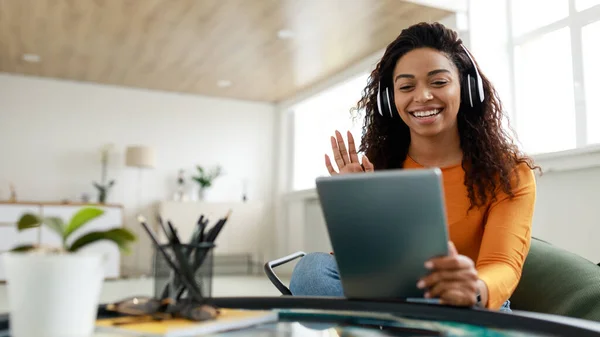 Black woman having video call using tablet and waving hand — Stockfoto