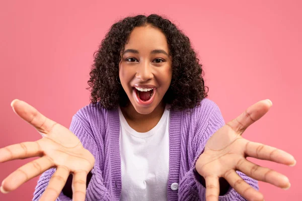 Emotional young African American woman gesturing hands at camera, shouting OMG, celebrating big win on pink background — Stok fotoğraf