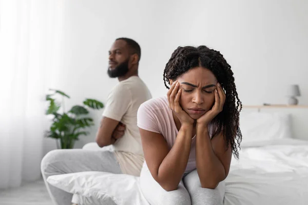 Sad offended millennial african american wife ignores upset husband after quarrel on bed — Stock fotografie