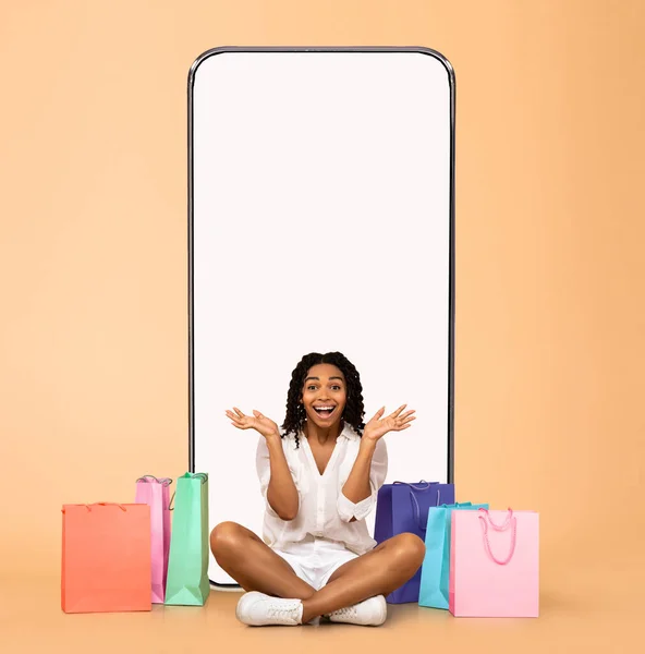Woman posing with white empty smartphone screen and shopper bags — Stok fotoğraf