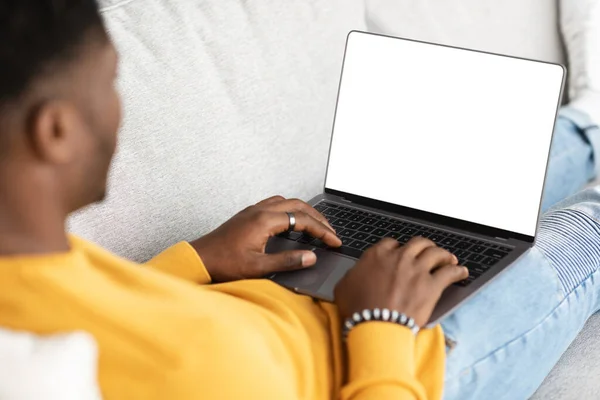 Unrecognizable black guy using laptop with empty screen — Foto Stock