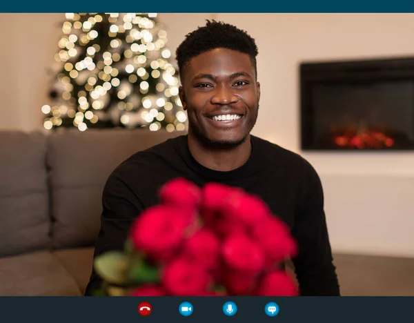 African Man Video Calling Holding Bouquet On Christmas Indoor — Stockfoto