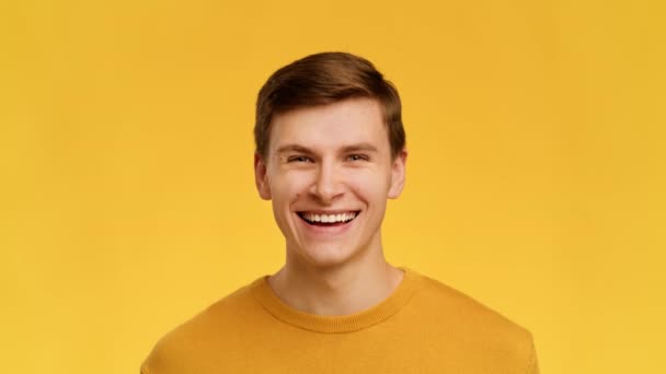 Man Smiling Raising Eyebrows Looking At Camera Over Yellow Background — Wideo stockowe