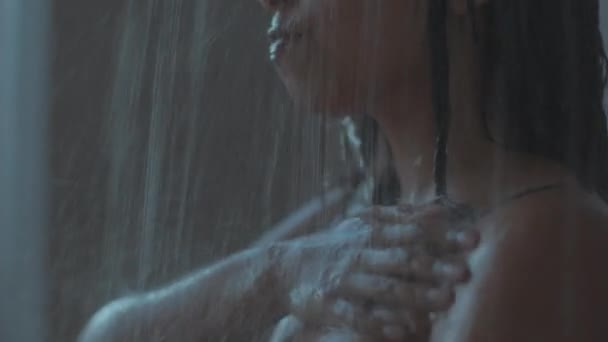 Young naked unrecognizable woman taking morning shower, washing body, standing under falling water drops, tracking shot — Stockvideo