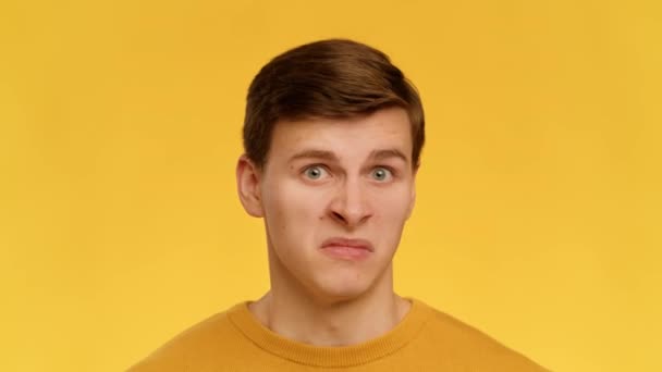 Disgusted Man Grimacing Smelling Bad Stink Standing Over Yellow Background — Vídeos de Stock