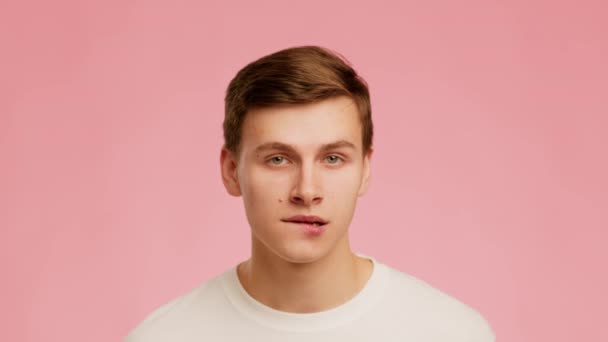 Playful Millennial Guy Biting Lips Posing Over Pink Background — Wideo stockowe