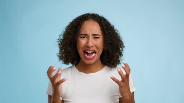 Portrait Of Emotional Black Female Shouting Over Blue Studio Background — Stockvideo