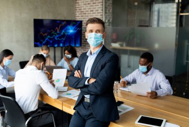Ofisteki Yeni Normal. Şirketin CEO 'su toplantı odasında tıbbi maske takıyor.