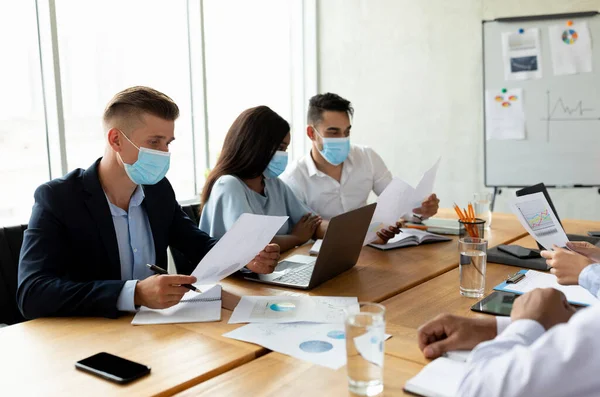Grupo de colegas multiétnicos que usan máscaras protectoras para la cara trabajando juntos en el cargo — Foto de Stock