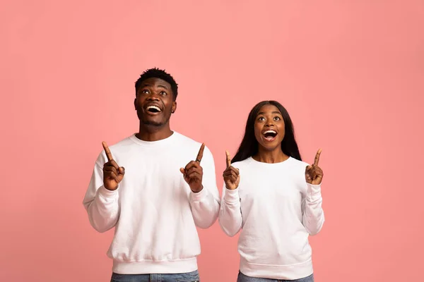 Emotional african american man and woman pointing at copy space — Stockfoto