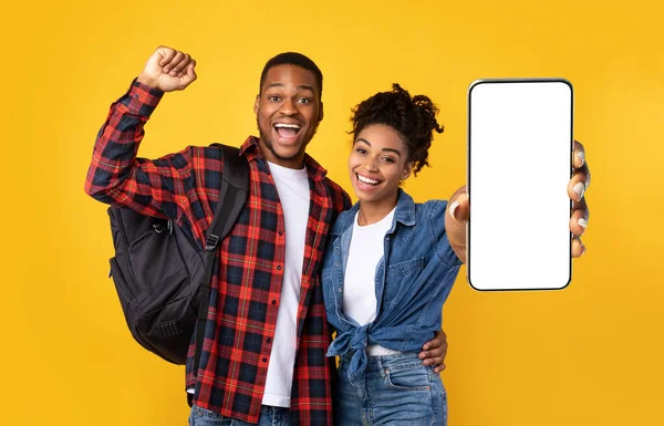 Black couple showing white empty smartphone screen and gesturing yes — Stockfoto