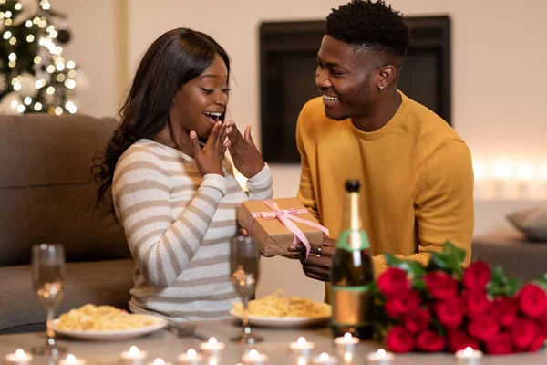 Black Boyfriend Surprising Girlfriend With Wrapped Gift Celebrating Valentine Indoor — Fotografia de Stock