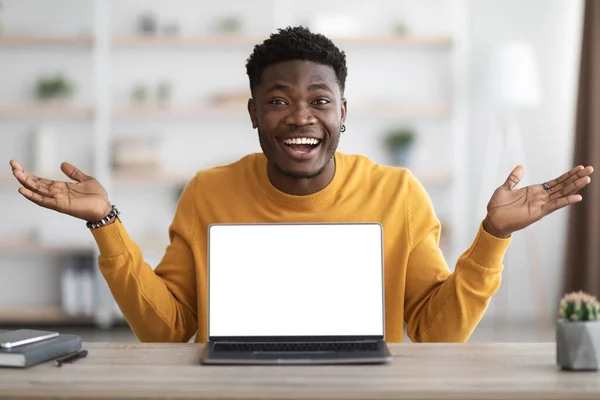 Emotional black guy using laptop with empty screen — Stock Fotó