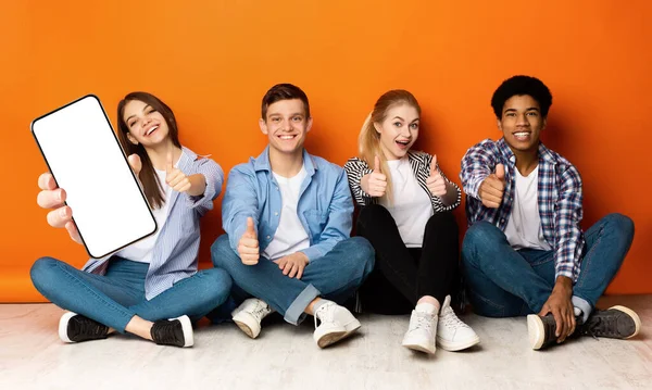 Group Of Teens Sitting On Floor And Demonstrating Blank Smartphone, Mockup — Zdjęcie stockowe