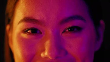 Asian Female Eyes With Natural Makeup Illuminated With Colorful Neon Light