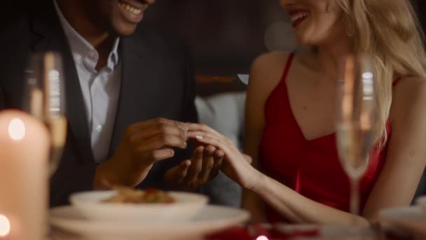 Czarny mężczyzna oświadczając się dla kobieta wprowadzenie w pierścień w restauracja — Wideo stockowe