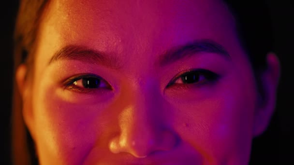 Yeux féminins asiatiques avec maquillage naturel illuminé avec de la lumière au néon colorée — Video