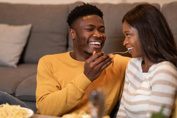 African American Boyfriend Feeding Girlfriend Eating Pasta Together At Home — Zdjęcie stockowe