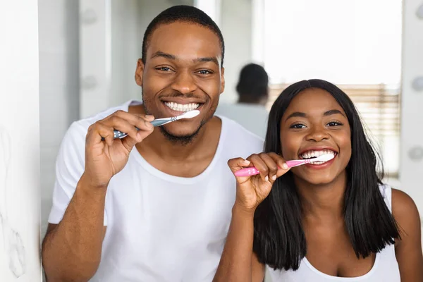 Buenos días Rutina. Retrato de sonriente pareja negra cepillando dientes en el baño juntos — Foto de Stock