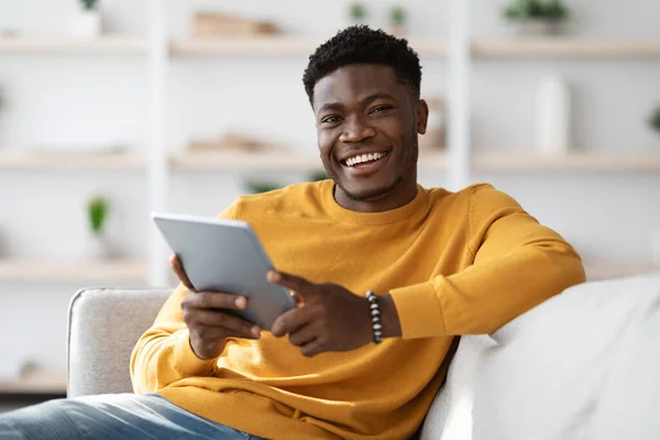 Chico negro feliz usando tableta digital en casa —  Fotos de Stock