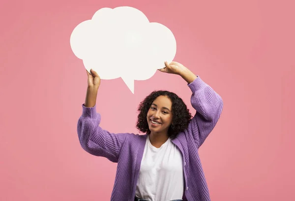 Cheerful black woman holding blank speech bubble on pink studio background, mockup for your ad design — Zdjęcie stockowe