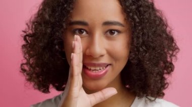 Black Woman Whispering Sharing Secret Over Pink Background