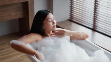 Korean Woman Taking Relaxing Bath With Foam In Bathroom Indoor