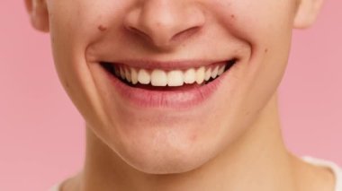 Male Face Smiling Showing White Teeth Over Pink Background, Cropped