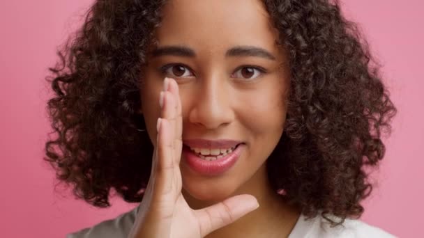 Black Woman Whispering Sharing Secret Over Pink Background — Stockvideo