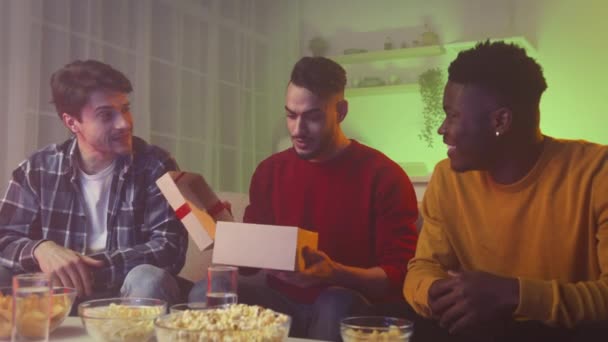 Best gift from bros. Multiethnic guys greeting their friend, middle eastern guy opening box, laughing together at home — Stock video