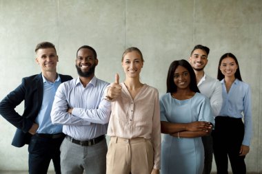 Başarılı bir kariyer anlayışı. Gri Duvar Arkaplanı Üzerinde Birlikte poz Veren Çok Irklı İş Adamları