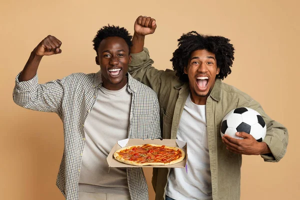 두 명의 탁월 한 흑인 축구 팬들 이 축구와 피자를 들고 있다 — 스톡 사진