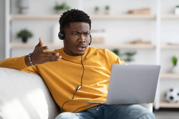 Furious black guy having video call, using laptop at home — Stock Fotó