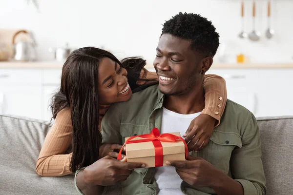 Känslomässig afrikansk amerikansk kvinna kramar sin älskare, ger present — Stockfoto