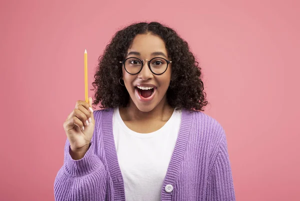 Excited black lady raising pencil up, having creative idea or inspiration on pink studio background — 스톡 사진